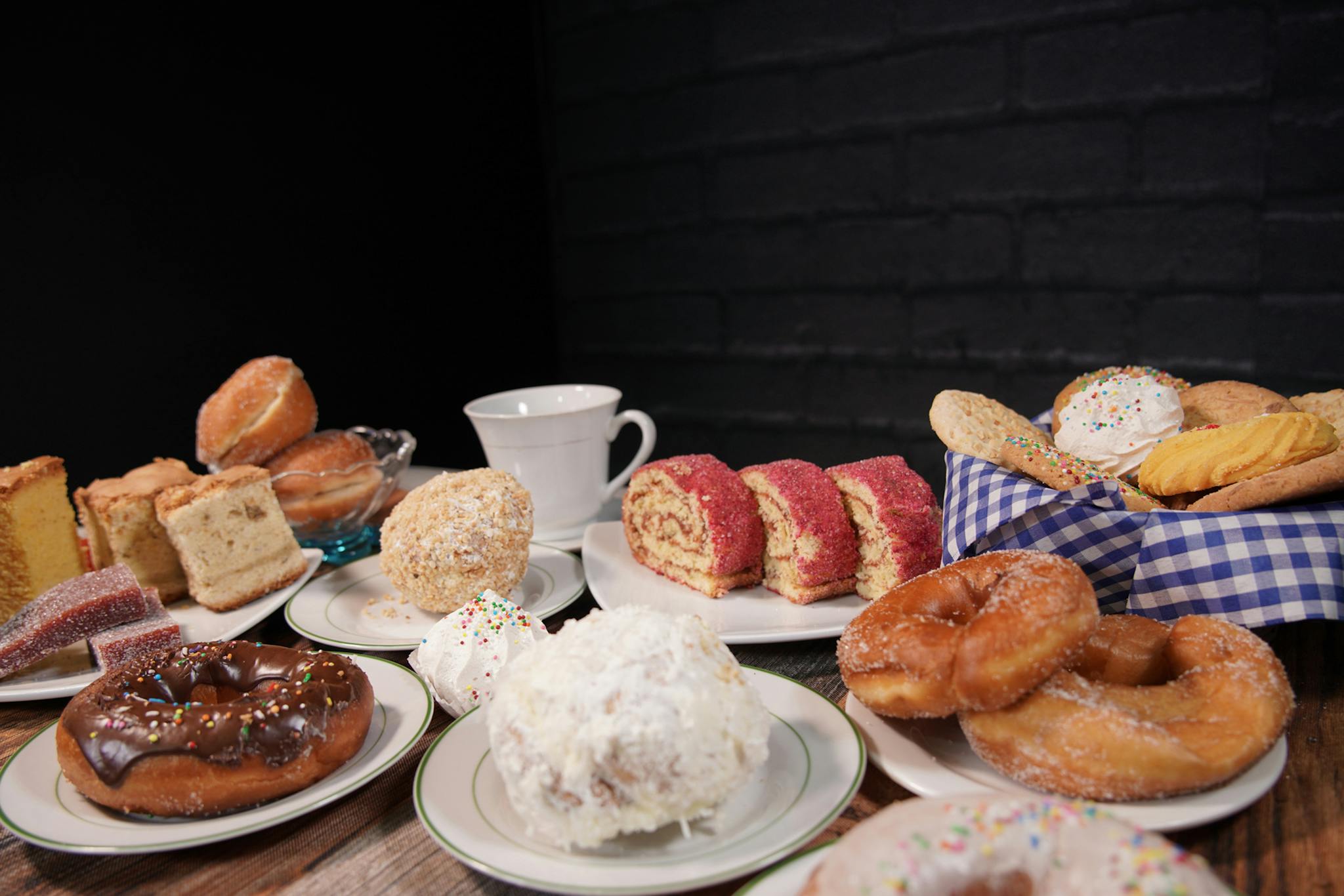 A delectable assortment of pastries and cakes on plates with a coffee mug, perfect for breakfast or dessert.